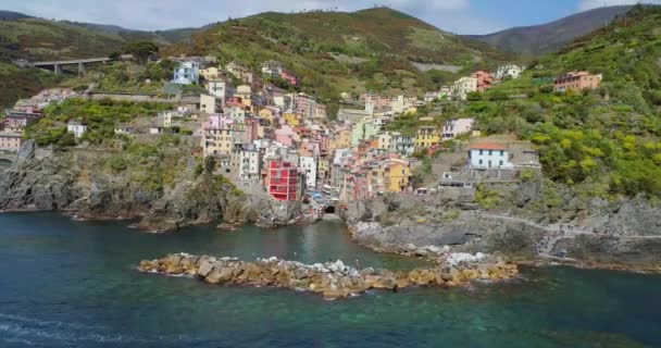 Aerial view of travel landmark destination Riomaggiore, a small mediterranean sea town, Cinque terre National Park, Liguria, Italy. Morning with sun and clouds. 4k aerial drone orbit video shot — Stock Video