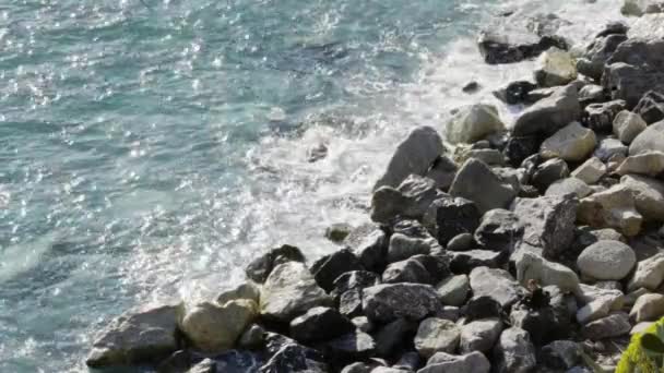 Luchtfoto overhead uitzicht op oceaan Middellandse zee golven bereiken en crashen op rotsachtige kust strand kust, in de buurt van de Cinque terre National Park, Ligurië, Italië. Zonnig weer. 4 k bovenaanzicht drone video schot kant — Stockvideo