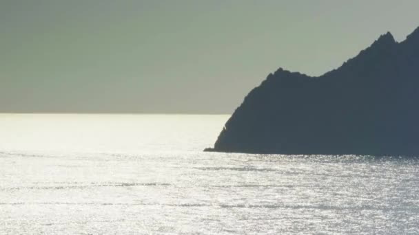 Vista al mar mediterráneo en la costa rocosa de la playa, cerca de destino turístico Parque Nacional Cinque terre, Liguria, Italia. Reflejos meteorológicos al atardecer. 4k vista superior drone lado tiro de vídeo — Vídeo de stock