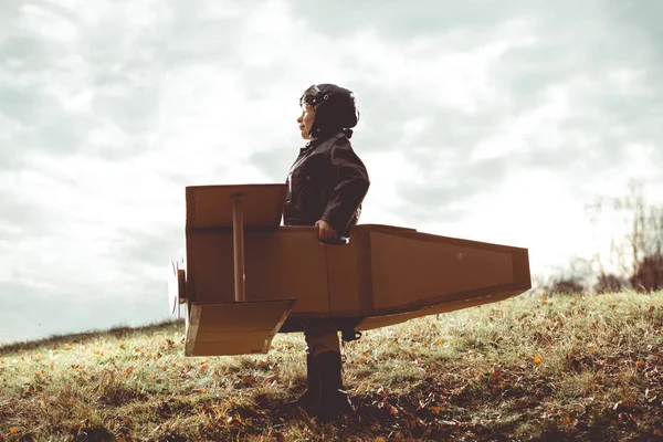 Framifrån vintage pilot pojke flygning av fantasi på kartong plan utomhus — Stockfoto