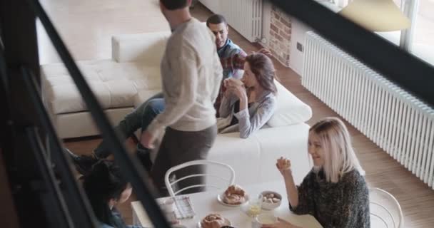 Amigos conversando tomando café da manhã e relaxando no sofá interior — Vídeo de Stock