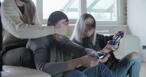 Amigos disfrutan relajarse en el sofá jugando videojuegos — Vídeo de stock