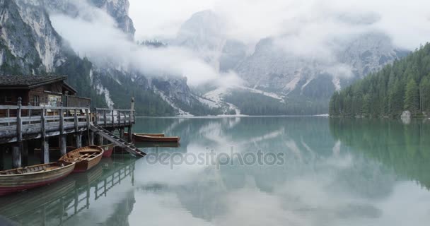 Boathouse with wood pier and boats on Braies lake — Stock Video