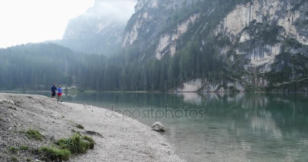 Couple walking near Braies lake in cloudy day — Stock Video