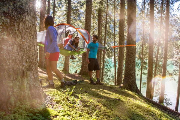 Homem e mulher pendurado barraca camping na floresta — Fotografia de Stock