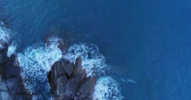 ulaşan ve kayalık sahil plaj sahil üzerinde çökmesini dalgalar okyanus Akdeniz deniz hava havai görünümü. Kötü hava. 4 k üstten görünüm yavaş 60 fps dron yan video çekim