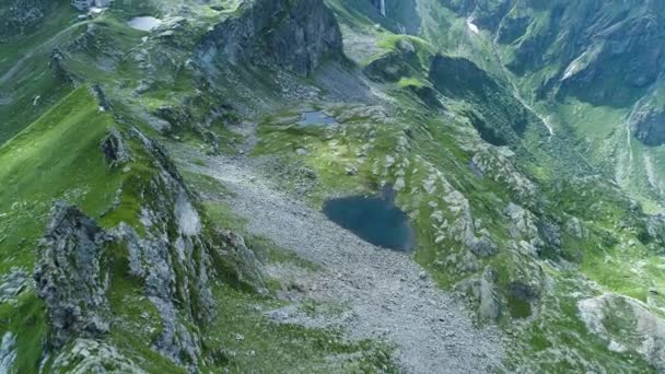 Moving forward over majestic alpine mountain valley with lakes in sunny cloudy summer.Europe Alps outdoor green nature scape mountains wild aerial establisher.4k drone flight establishing shot — Stock Video