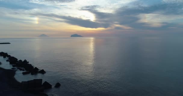 Moviendo vista aérea lateral de la playa mediterránea de la orilla del mar en Salina con el volcán lejano de Stromboli. Naturaleza al aire libre viajan Establecimiento, Italia, Sicilia Isla Eólica. — Vídeos de Stock