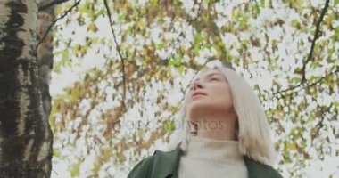 Ayrıntı yüzünde. Sonbahar ormanda yürüyüş Beyaz sarışın kadın slomo. Önünde gimbal takip. Hikaye anlatımı çok genç yetişkin insanlar sonbahar forest.4k yavaş çekimde video yalnız