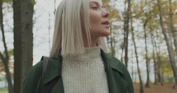 Detail op gezicht. Kaukasische blonde vrouw slomo rondkijken vallen bossen. Static.Storytelling echt volwassen jongeren alleen in najaar forest.4k slow motion video — Stockvideo