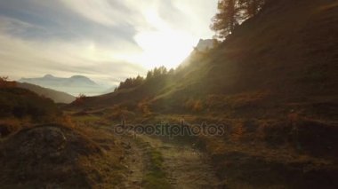 Pov, sonbahar yolda yürüme için Vadisi ve karlı dağ güneş batımında flare. Güneşli sonbahar günü renkli kırmızı orman vahşi doğa dağ outdoors.4k'da yürüyüş gelin görünümü kurulması video