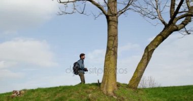 Fotoğraflar için seyir ormanda hiking adam. Aşağıdaki yan. Sonbahar mevsiminde fotoğraf Shoot kırsal alanda yürüyüş gerçek insanlar bin yıllık yolcu backpacker yetişkin erkek fotoğrafçı. 4k video