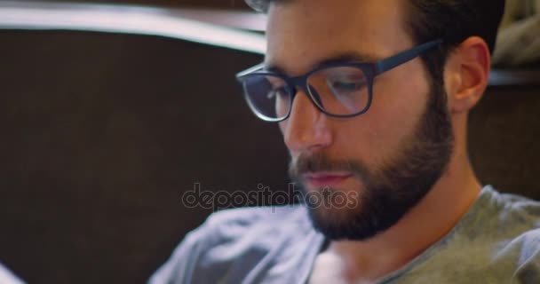 Youg millennial hombre relajante leyendo periódico en casa en vestimenta casual. Vídeo 4k — Vídeos de Stock