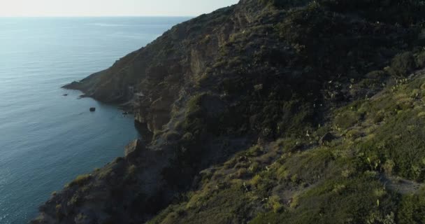 Moviendo vista aérea lateral del mar mediterráneo salvaje verde costa rocosa. Ambiente de la naturaleza al aire libre viaje Establecimiento, Italia, Sicilia Salina Isla Eólica. — Vídeos de Stock