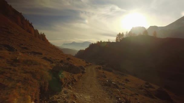 POV caminando en el camino de otoño a los bosques, valle y montajes nevados al atardecer con flare.Sunny día de otoño Senderismo en colorido bosque rojo naturaleza salvaje montaña al aire libre.4k punto de vista establecer video — Vídeos de Stock