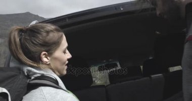 Sırt çantası yol veya Suv dört tekerlekli sürücü araç araba bagajı dışından çekici bir adam. Kaç kişi aşk sonbahar açık gezisinde doğada. Sonbahar güneşli günü. 4 k ağır çekim video