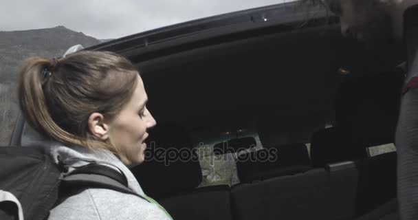 Hombre tomando la mochila de fuera de la carretera o SUV vehículo de tracción en las cuatro ruedas del coche del maletero. Pareja de personas enamoradas de otoño viaje al aire libre en la naturaleza. Día soleado de otoño. 4k video en cámara lenta — Vídeos de Stock