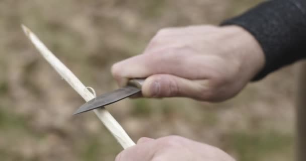 Mann schneidet Holz mit Messer, um Mahlzeit zuzubereiten. Paar verliebte Herbst Outdoor-Ausflug in die Natur. Herbstsonniger Tag. 4k Zeitlupenvideo — Stockvideo