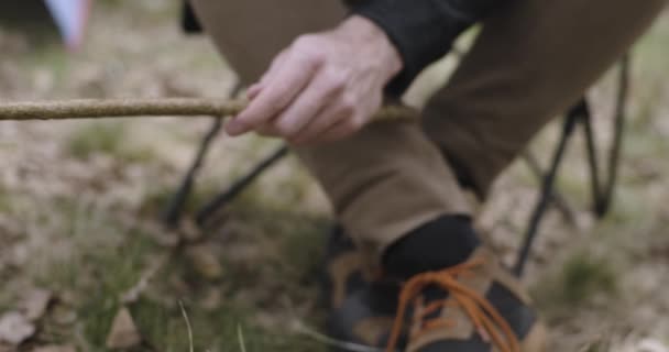 Mand madlavning måltid nær camping telt. Opvarmning hotdog detaljer. Par mennesker i kærlighed efterår udendørs tur i naturen. Efterårssolskinsdag. 4k slow motion video – Stock-video