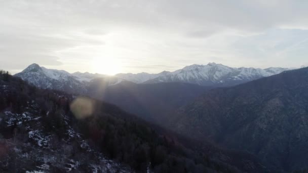 移动边在光秃的秋天树林森林和雪山在秋季或冬季日落。室外阳光明媚自然花葶岩石山与雪野生空中 establisher.4k 无人机飞行建立射击 — 图库视频影像