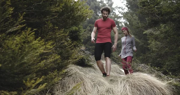 Atleta mujer y el hombre caminando por bosque path.Real personas corredor entrenamiento deportivo en otoño o invierno en la naturaleza salvaje montaña al aire libre, mal tiempo niebla. — Foto de Stock