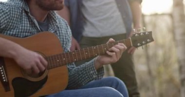 Adam gitar çalarak rahatlatıcı şöminenin sıcak beverage.real arkadaşlar insanlar açık kamp çadır tatil sonbahar gezisi ile kapatın. Sonbahar güneşli bir günde doğa, beraberlik ve friendship.4k video