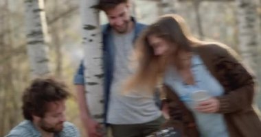 Gitar ve kadın şaka alarak yaklaşık ateş place.real arkadaşlar insanlar açık hava kamp çadır tatil sonbahar gezisi oynayan adam. Sonbahar güneşli bir günde doğa, beraberlik ve dostluk. 4k video