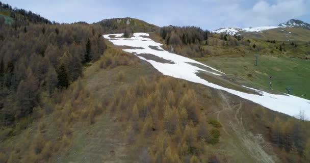 秋に山の森林と雪のスキー トラックの森松カラマツの上発見楽しみにして移動します。秋アルプス屋外の自然景観山野生の空中 establisher.4k 無人飛行エスタブリッシング ・ ショット — ストック動画