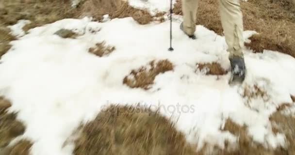 Hiker man with backpack walking on snowy trail path.Following behind legs detail.Real backpacker people adult hiking or trekking in autumn or winter in wild mountain outdoors nature,bad foggy weather. — Stock Video
