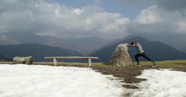 Atleta hombre corredor calentamiento o enfriamiento stretching.Real personas sendero adulto corriendo entrenamiento deportivo en otoño o invierno en la naturaleza salvaje montaña al aire libre, mal tiempo niebla. — Vídeos de Stock