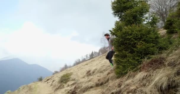 Sportowiec człowiek biegnie ścieżka śnieg. Po przodu. Prawdziwych ludzi dorosłych trail runner sport szkolenie jesienią lub zimą w dzikie góry na zewnątrz natura, złe mglisty weather.4k wideo — Wideo stockowe