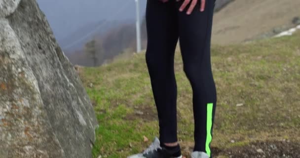 Atleta hombre corredor calentamiento o enfriamiento stretching.Real personas sendero adulto corriendo entrenamiento deportivo en otoño o invierno en la naturaleza salvaje montaña al aire libre, mal tiempo niebla. — Vídeos de Stock