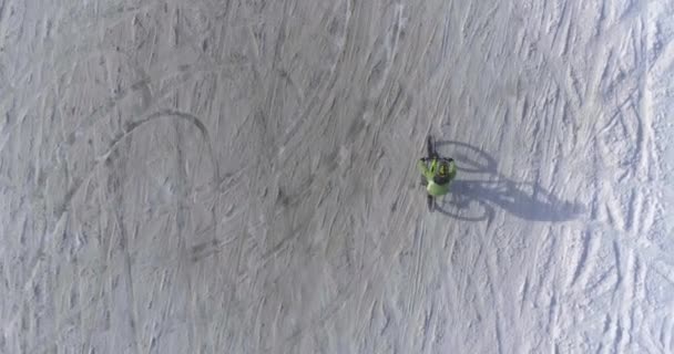 Над головой велосипедиста, катающегося на велосипеде по снежной тропе зимой на электронном велосипеде МТБ. Велосипедист на велосипеде на снегу на открытом воздухе зимой. 4k видео полета беспилотника — стоковое видео