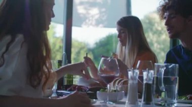 Yemek ve konuşmak kadın ve erkek. Dört beyaz arkadaş Akdeniz İtalyan Salata, et biftek ve ekmek öğle veya akşam yemeği insanlar. Yaz Partisi evde modern ev 4k el video
