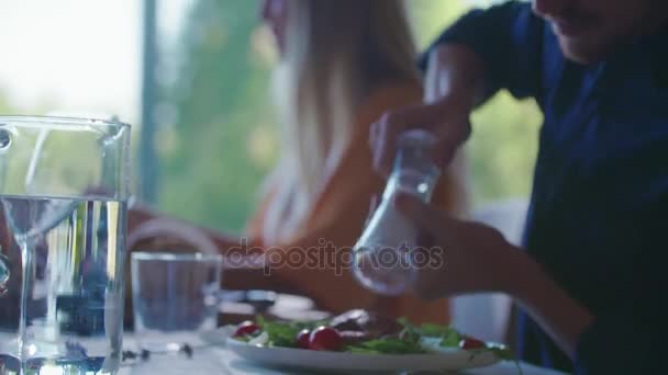 남자는 접시에 소금이 후추 밀을 사용 하 여입니다. 4 명의 백인 친구 사람들 지중해 이탈리아 샐러드, 고기 스테이크와 빵 점심 또는 저녁 식사. 현대 집 4 k 휴대용 비디오에서 집에서 여름 파티 — 비디오