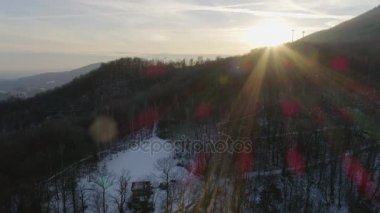 Hava drone uçuş karlı orman ormanda günbatımı insanlar yürürken, insanlar ile üzerinden. Dağ doğa dışarıda kışın karda. Güneş light.travel Alps keşfetmek. 4 k üstten görünüm video