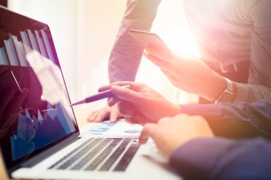 İki arkadaşları laptop ve smartphone kullanarak yeni küresel finansal strateji planı üzerinde çalışıyor. Modern iş takım yenilik kavramı. Proje toplantısı ofisinde sanal grafik ve grafik veri arayüzü ile