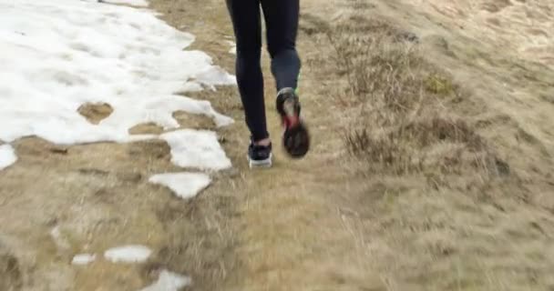 Idrottsman man kör genom snöiga väg. Efter bakom ben detalj. Riktiga människor vuxen trail runner sport utbildning i höst eller vinter i vilda berg utomhus natur, bad dimmigt weather.4k video — Stockvideo