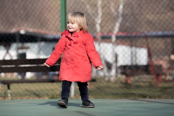 Candid jonge babymeisje dragen winterkleren lachen in zonnige dag buiten — Stockfoto