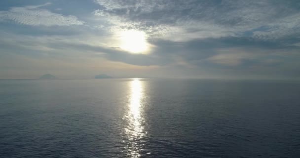 Moviendo hacia atrás vista aérea de la playa de la orilla del mar mediterráneo en Salina con lejano volcán Stromboli. Naturaleza al aire libre viajan Establecimiento, Italia, Sicilia Isla Eólica. — Vídeos de Stock