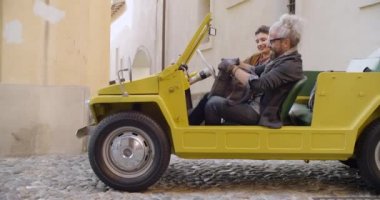 Bagaj veya durdurulan araç üzerinde oturmuş bavul arama adam. Gerçek çift aşk roadtrip tatil İtalyan seyahat Cabrio eski model araba üzerinde. 4 k el video