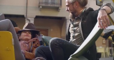 Erkek ve kadın ile gülümseyen güneş gözlüğü, rahatlatıcı ve konuşmaya liying durdurulan araç üzerinde oturmuş. Side.Caucasian kaç aşk roadtrip tatil İtalyan seyahat Cabrio vintage car.4k el video içinde