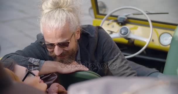 Hombre y mujer con gafas de sol sonriente, relajante y hablando sentado en vehículo.Portrait.Pareja caucásica en el amor roadtrip vacaciones viajes italianos en coche vintage convertible.4k video portátil — Vídeos de Stock