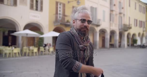 Bärtiger erwachsener Mann mit grauen Haaren Portrait mit Gepäcktasche auf Stadt place.caucasian Roadtrip Urlaub Italienisch reisen. — Stockvideo