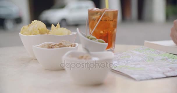 Woman talking french fries during cocktail aperitif outside of cafe.Medium shot. Caucasian couple in love roadtrip vacation italian travel — Stock Video
