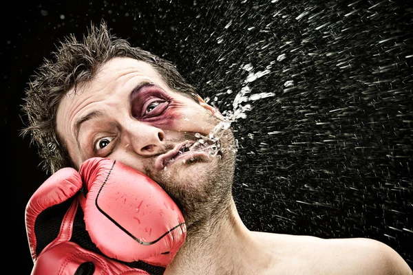 Silly boxer man takes a punch in the face isolated on black.funny concept portrait — Stock Photo, Image