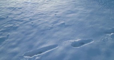 Hava üstten görünüm güneşli bir günde karlı kış düz ayak izi ile üzerinde ileriye doğru. Backlight.Snow sezon beyaz detay ILDIZ Künye tracks.4k drone uçuş atış kurulması ile