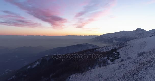 在日落或日出时, 在冬季白雪皑皑的高山和森林森林的前空中俯视图。蓝色小时黄昏或黎明阿尔卑斯高山雪季节制订. 4 k 无人机飞行建立射击 — 图库视频影像