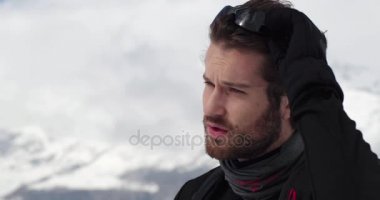 Güneş gözlüğü koyarak ve yürüyen adam yüz detayını. Dağcılık Kayak etkinliği. Alp dağ açık insanların kış sporda kayakçı. Ağır çekim 60p 4 k video