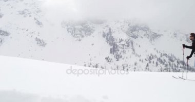 Kar ridge manzara artan yürüyen adam. Dağcılık Kayak etkinliği. Alp dağ açık insanların kış sporda kayakçı. Yan görünümü. Ağır çekim 60p 4 k video